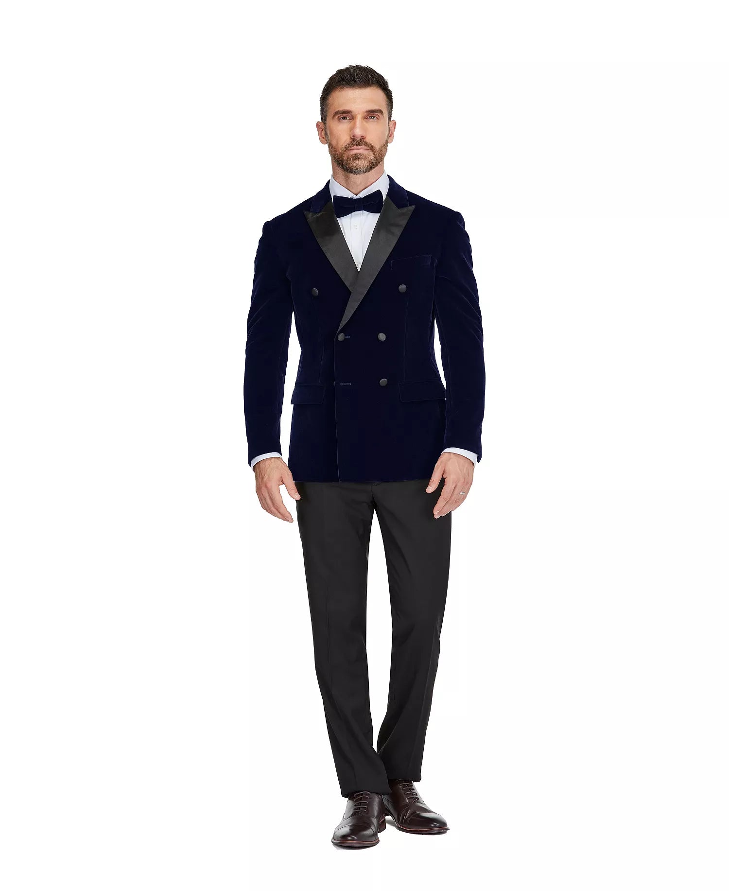 Man wearing a navy blue tuxedo with a white shirt and black bow tie on a white background