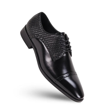 Black dress shoe with decorative bow on a white background