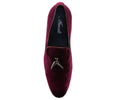Burgundy velvet loafer with a decorative charm on a white background